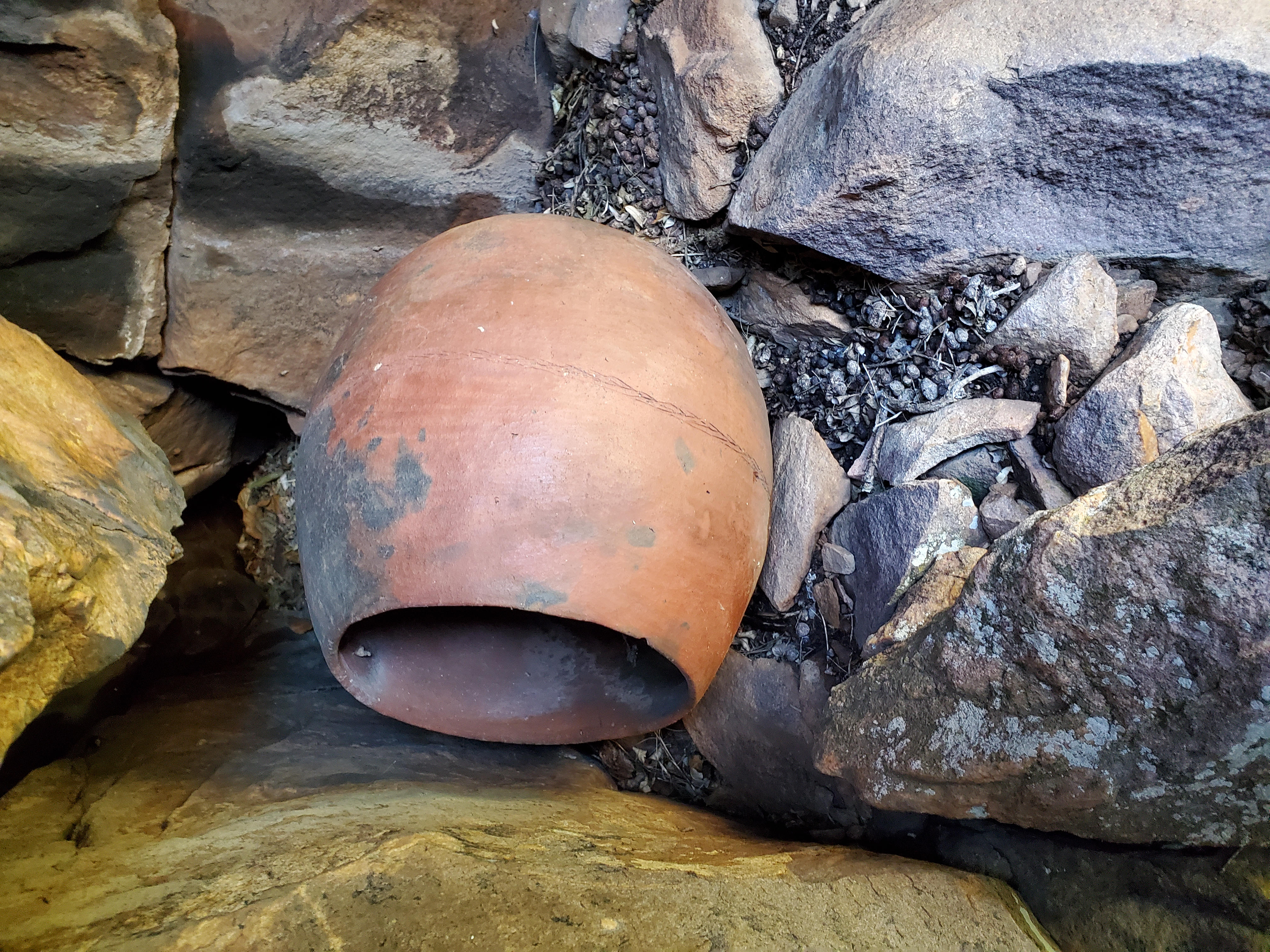 The clay pot high on a cliff in the shade.