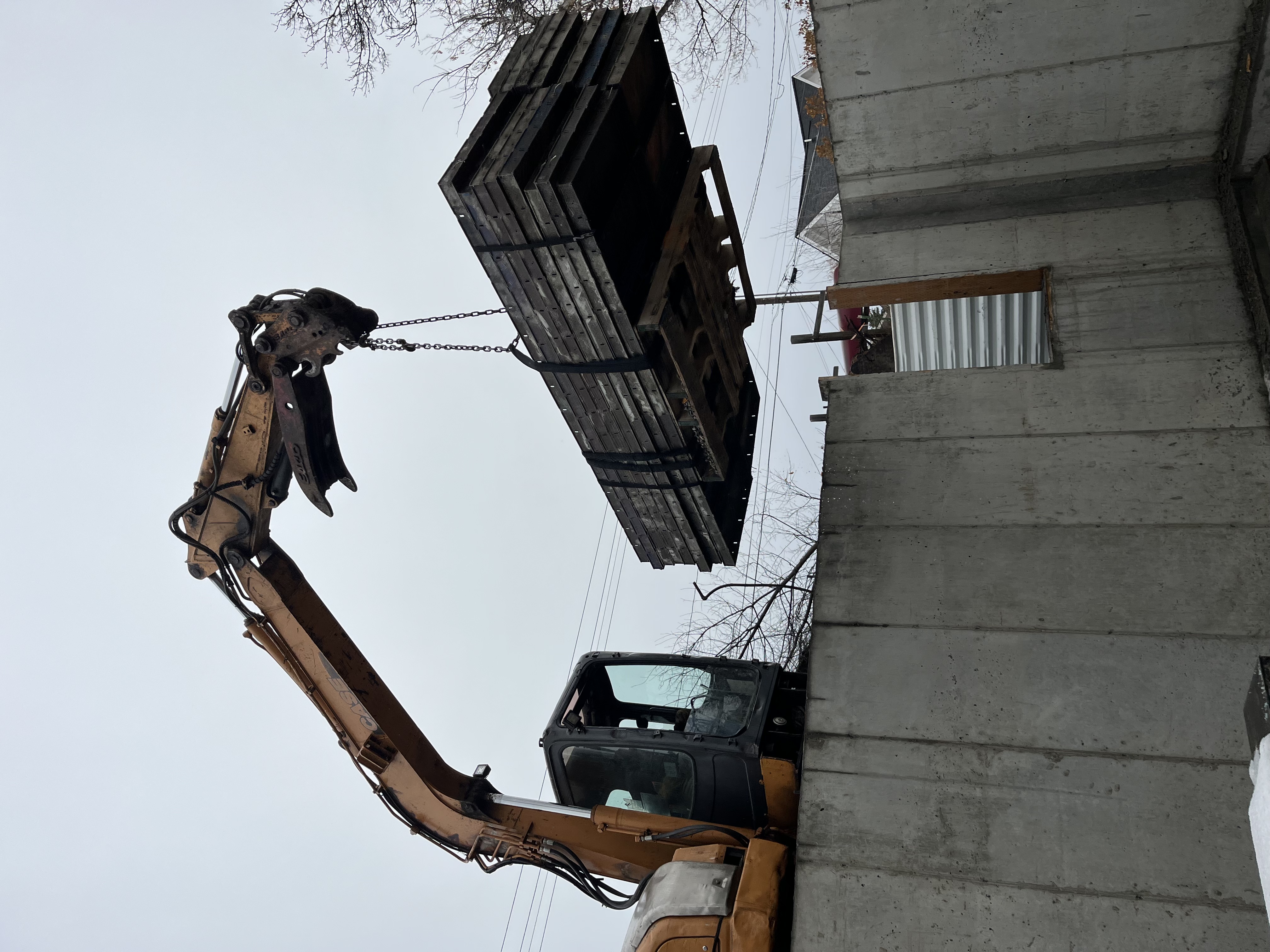 Excavator pulling forms out of the hole.